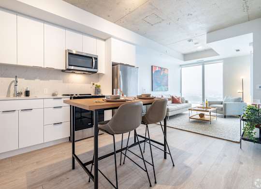 A modern kitchen with white cabinets and a dining table with chairs.