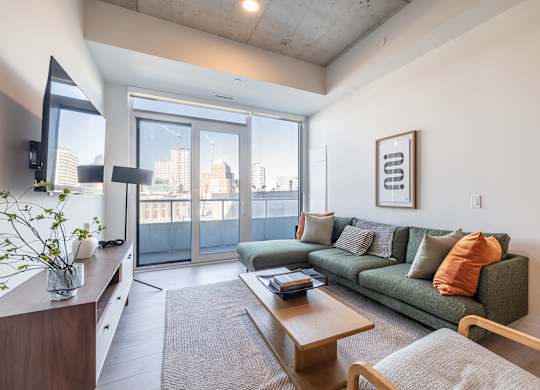 A living room with a green couch and a wooden coffee table.