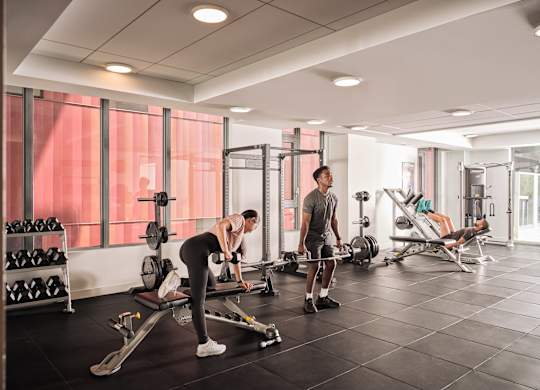 A man is working out in a gym with a woman.
