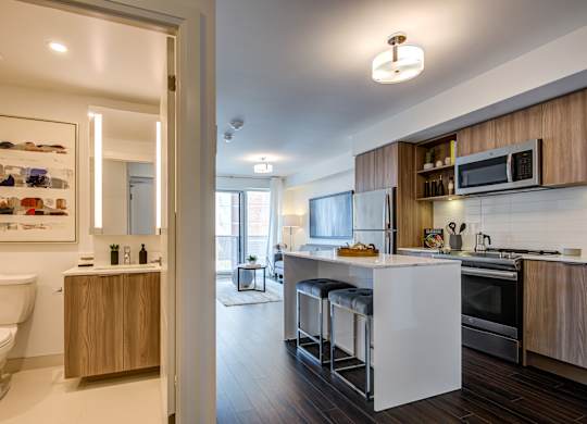 A modern kitchen with a white countertop and wooden cabinets.