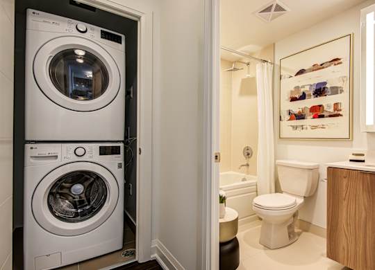 A white washing machine is in a small laundry room.