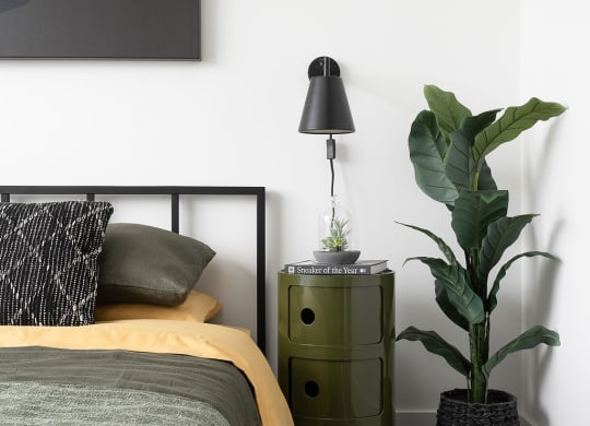 bed with nightstand and plant
