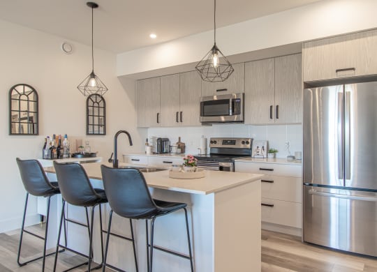 a kitchen with stainless steel appliances and a island with three stools