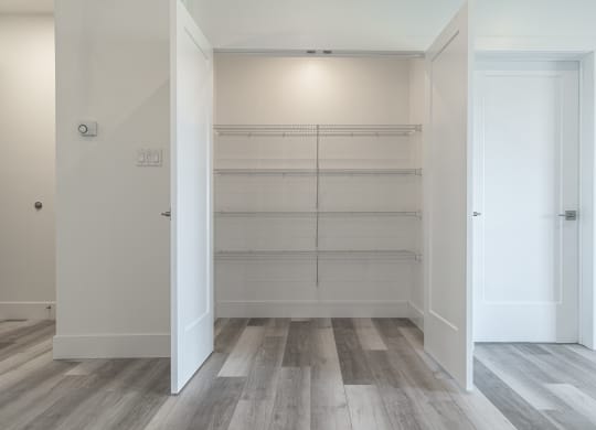 an empty room with white walls and wood flooring