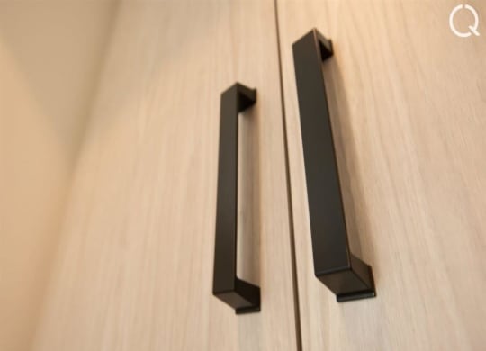 a pair of black handles on a wooden door