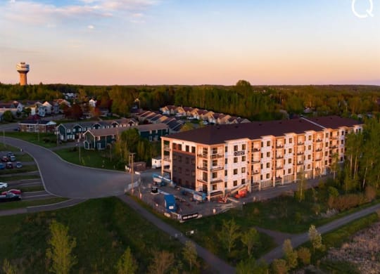 an aerial view of an apartment building at sunset
