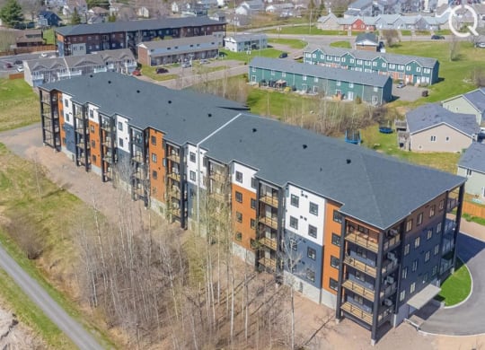an aerial view of an apartment building with a parking lot