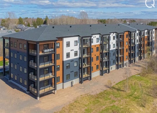 an aerial view of a large apartment building with a blue roof
