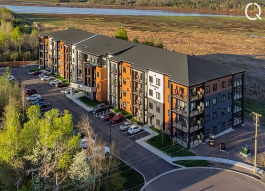 an aerial view of an apartment complex with a river in the background