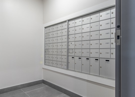 a wall of lockers in a room with white walls and flooring