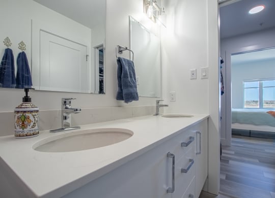 a white bathroom with two sinks and a mirror
