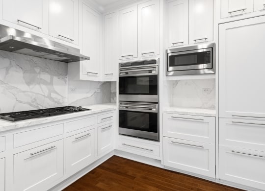 a kitchen with white cabinets and stainless steel appliances at HIGHGROVE, Stamford, CT, 06901