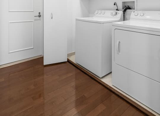 a washer and dryer in a room with white cabinets and a wood floor at HIGHGROVE, Stamford, CT