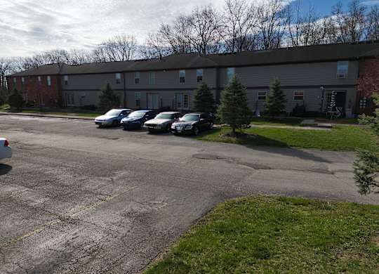 a parking lot with cars in front of a building
