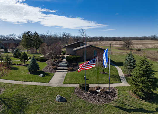 an aerial view of a house with two flags in front of it