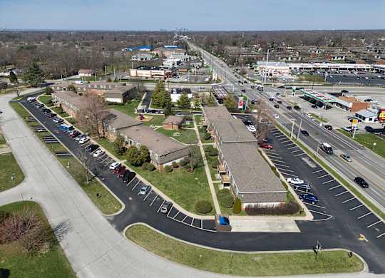 an aerial view of a parking lot with several buildings and a highway