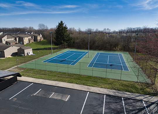 an aerial view of a tennis court with two tennis courts on a green tennis court