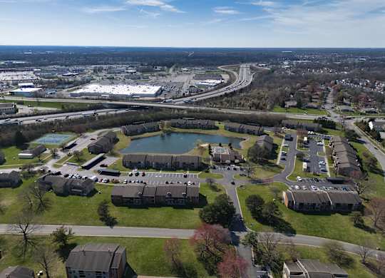 an aerial view of a park with a lake and buildings