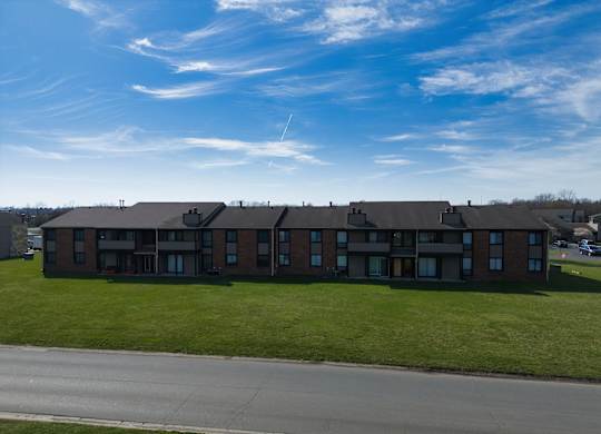 an apartment building on the side of a road with a blue sky