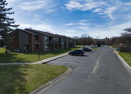an apartment complex with cars parked in a parking lot