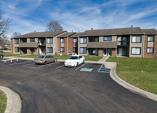 an apartment building with cars parked in front of it