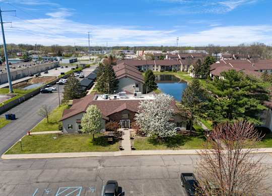 an aerial view of a neighborhood with a pond and houses