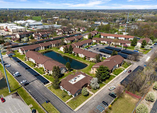 an aerial view of a neighborhood with houses and a pond