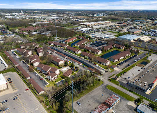 an aerial view of a neighborhood of houses and cars in a parking lot