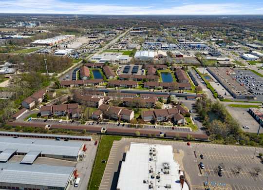 an aerial view of a city with cars parked in a parking lot