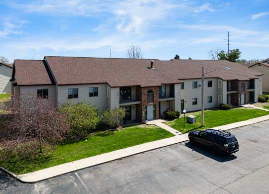 a large apartment building with a black car parked in front