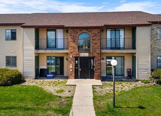 the front of a house with a sidewalk and grass