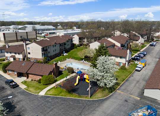 an aerial view of a neighborhood of houses with a playground and a pool