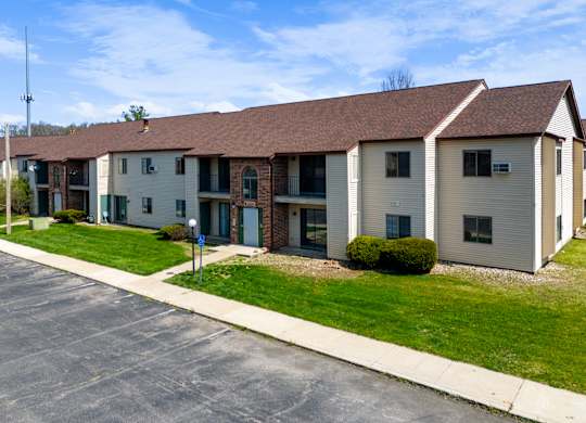 an apartment building with a sidewalk and grass
