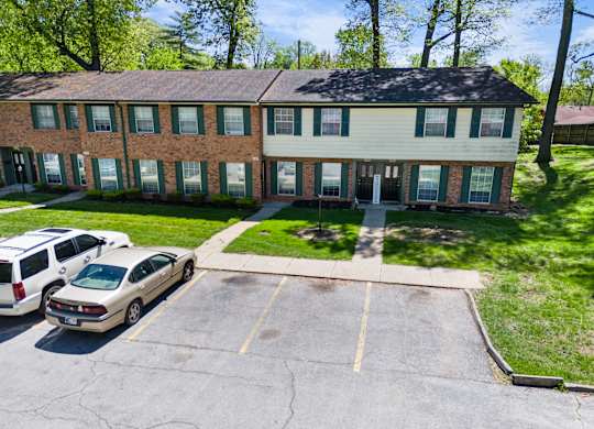 a large brick house with cars parked in front of it