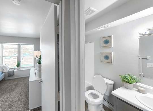 a bedroom with a bed and a bathroom with a toilet and a sink