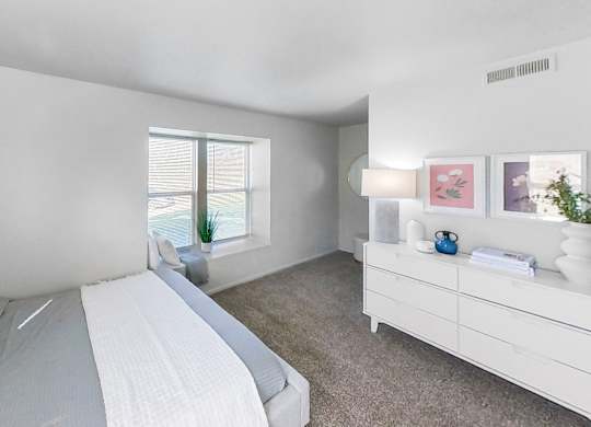 a bedroom with a bed and a dresser and a window