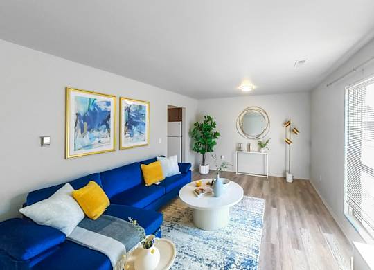 a living room with a blue couch and a round table