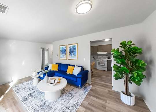 a living room with a blue couch and a white table