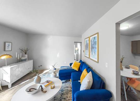 a living room with a blue couch and a white table