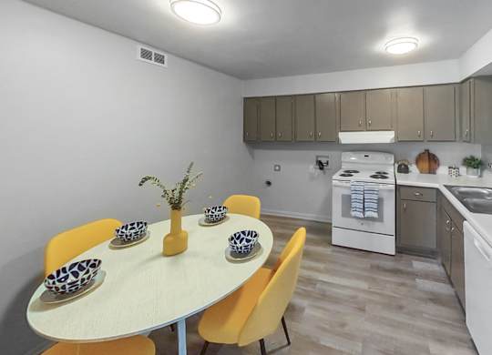 a kitchen with white appliances and a table with yellow chairs