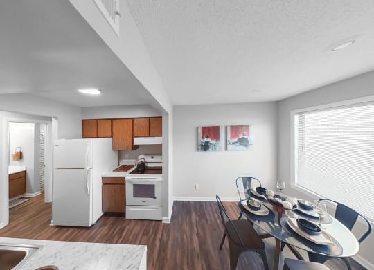 the living room and dining room of an apartment with a table and chairs