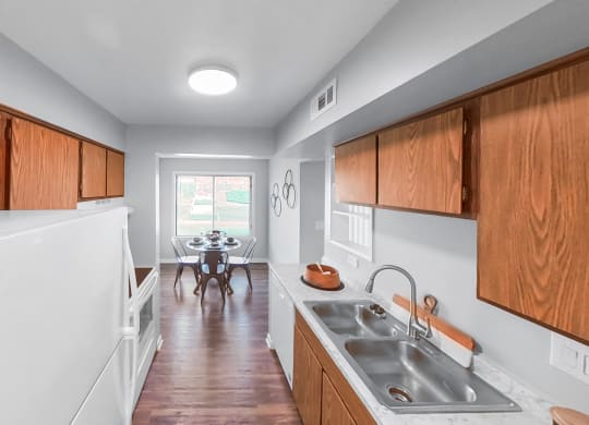 a kitchen with wooden cabinets and a sink and a dining room with a table