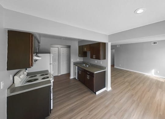 an empty kitchen and living room with wood flooring and