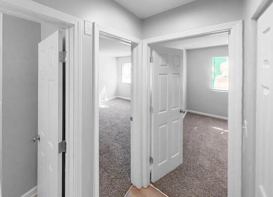an empty room with white doors and a carpeted floor
