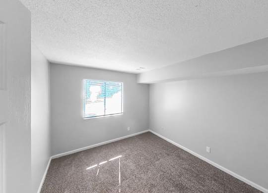 an empty room with carpet and a window