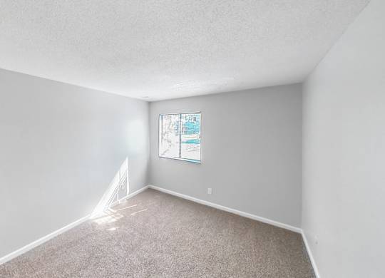 an empty room with white walls and a window