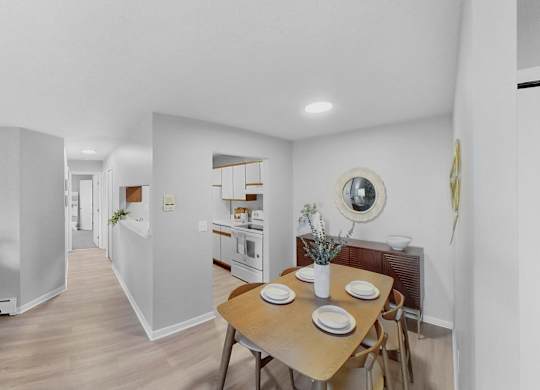 a dining room and kitchen with a table and chairs