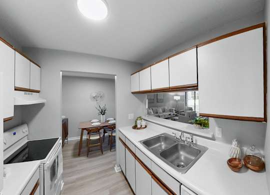 a kitchen with white counter tops and a stainless steel sink