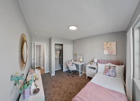 a bedroom with a bed and a desk and a window