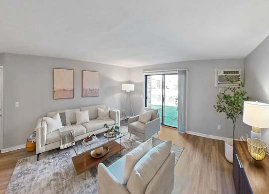 a living room with white couches and chairs and a sliding glass door